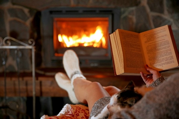 Person sitting with a book and a warm drink